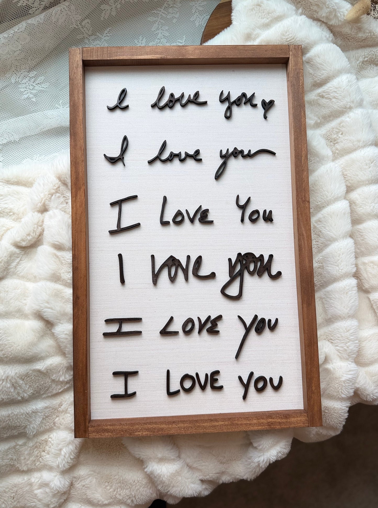 Framed letter board with 'I love you' text on a textured white surface